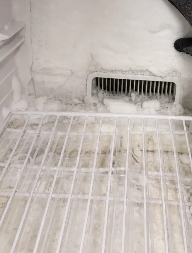 A frosted freezer back wall and its return-air vent, photographed with nobody in the frame.